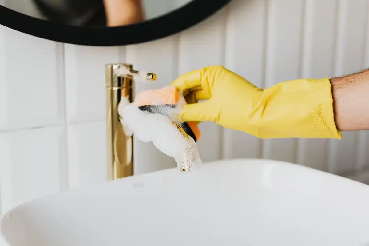 Nettoyage d'une surface de meuble en bois avec un chiffon humide et de l'eau savonneuse