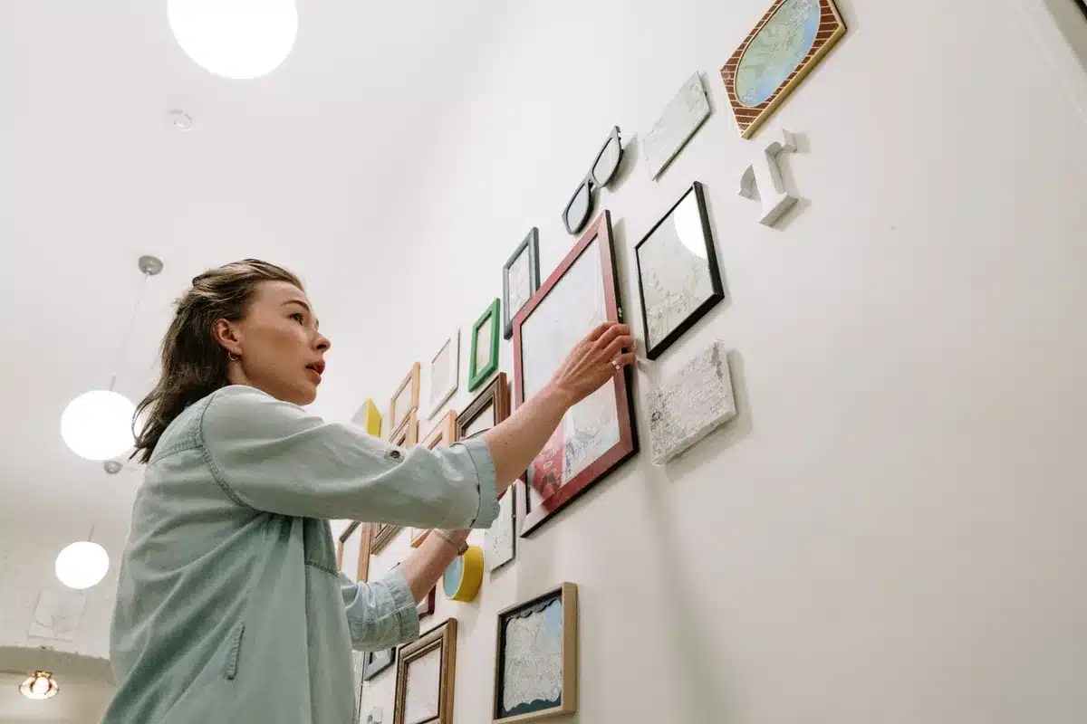 Galerie de cadres et affiches disposés sur un mur blanc