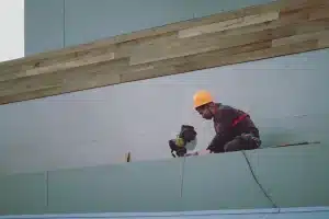 Ouvrier posant des panneaux d'isolation sur une façade extérieure