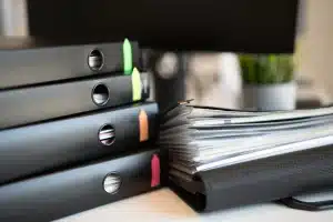 Mains tenant des documents de rénovation et des devis auprès d'une façade en rénovation
