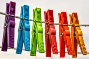 Mains gantées nettoyant l'intérieur d'une machine à laver avec un chiffon