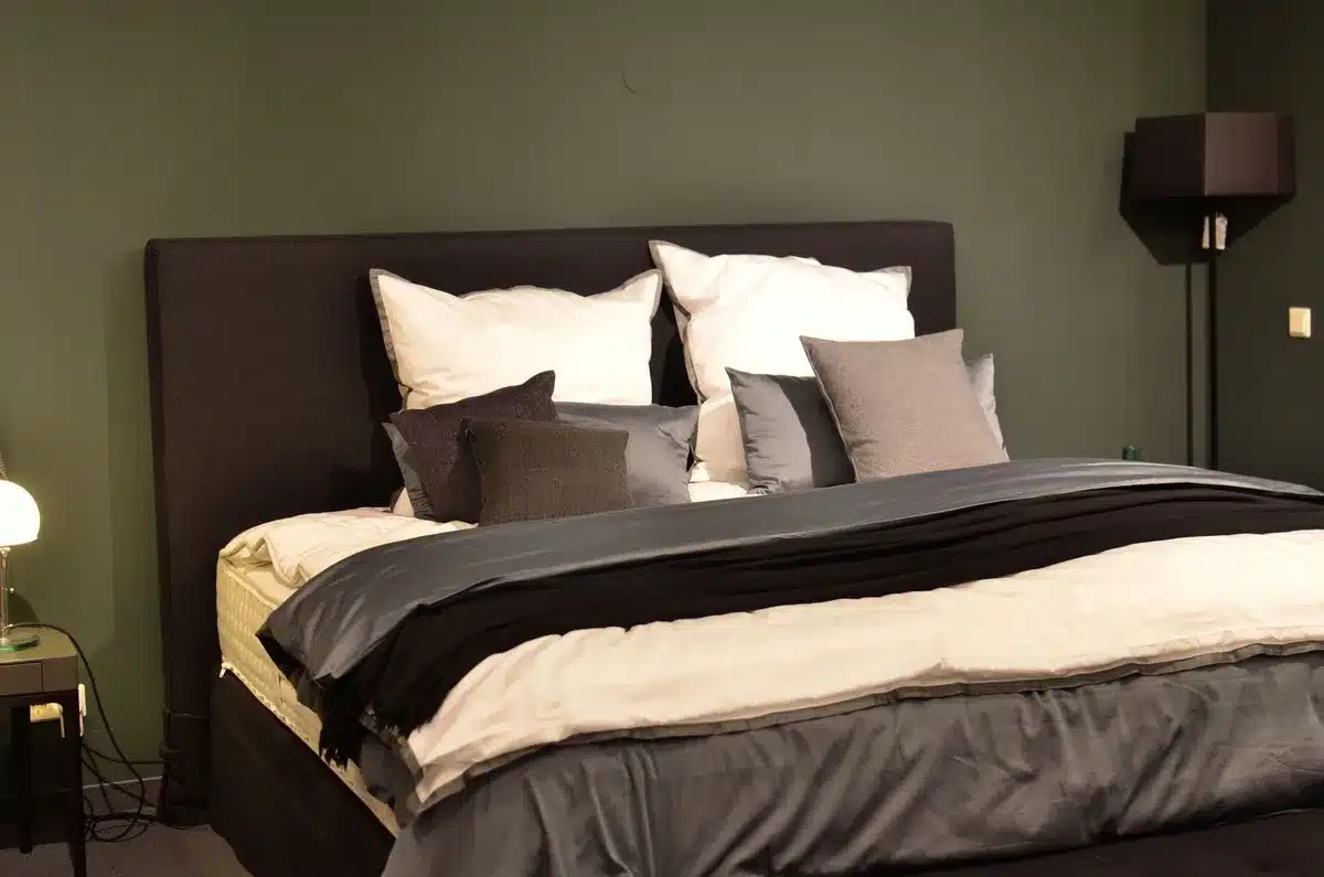 Lit avec plusieurs coussins et un plaid moelleux pour une ambiance cocooning