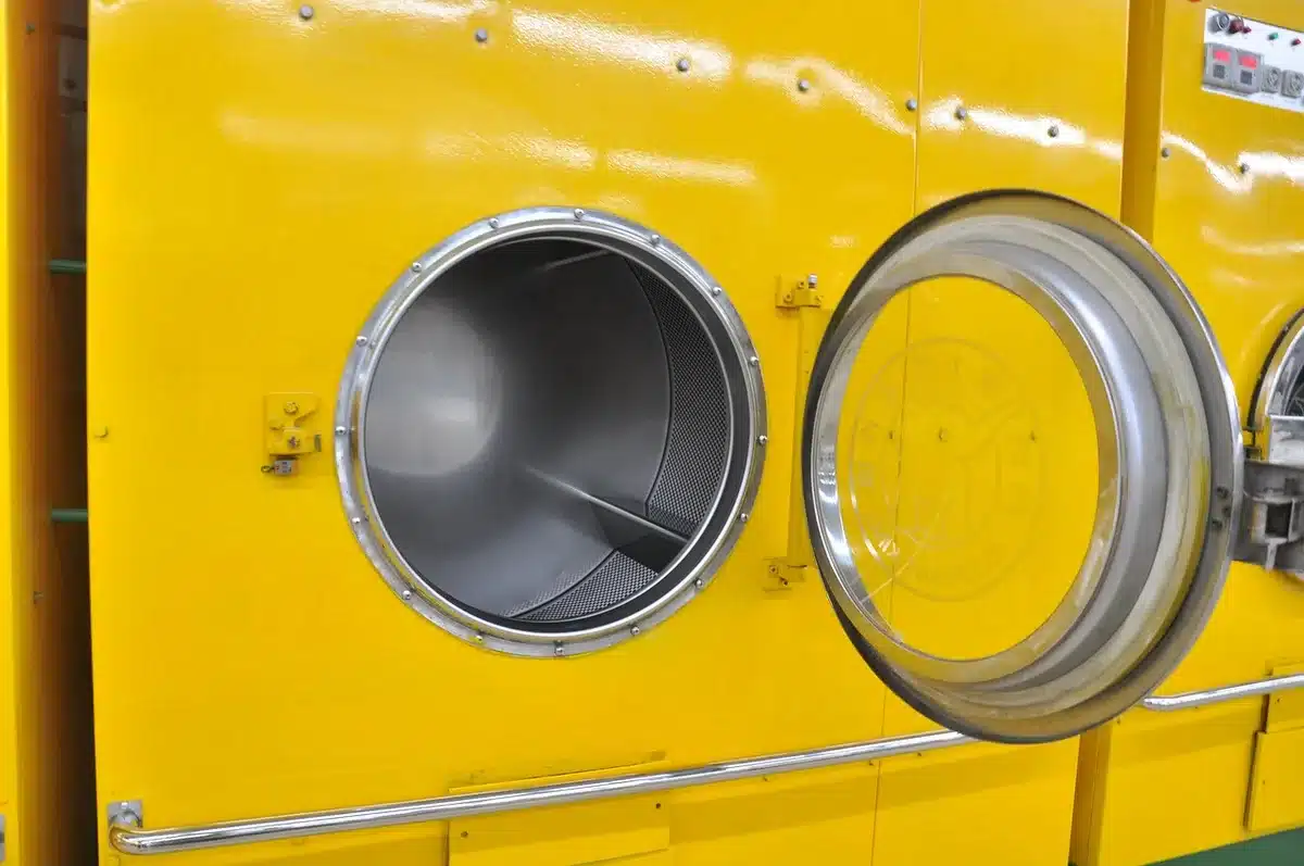 Vêtements blancs propres dans une machine à laver éclatants après traitement