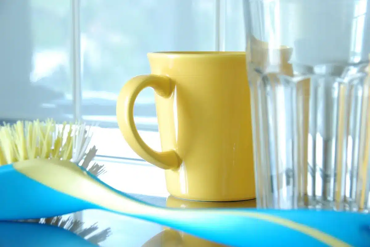 Pulvérisateur en verre, verre doseur et brosse sur une table de préparation