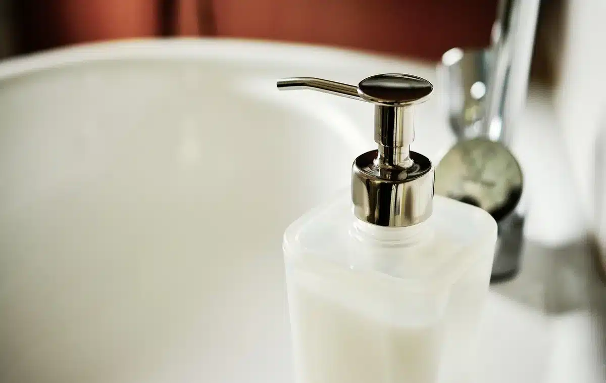 Brosse en train de frotter des joints de carrelage d'une salle de bain